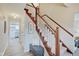 Elegant wooden staircase with a light gray carpet runner and a bench at the bottom at 4902 N Capitol Ave, Indianapolis, IN 46208