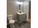 Modern bathroom with grey vanity, toilet, and dark tile floor at 503 E Clyde St, Frankton, IN 46044