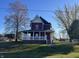 Two-story red house with white trim, a porch, and a well-maintained lawn at 503 E Clyde St, Frankton, IN 46044