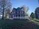 Side view of a charming two-story red house with white trim and a deck at 503 E Clyde St, Frankton, IN 46044