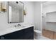 Modern bathroom with navy vanity, marble countertop, and walk-in closet at 10771 Holliday Farms Blvd, Zionsville, IN 46077