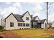 Rear view of a white brick house with a glass addition and landscaping at 10771 Holliday Farms Blvd, Zionsville, IN 46077