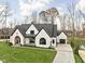 Stunning two-story home with white brick exterior, black accents, and a manicured lawn at 10771 Holliday Farms Blvd, Zionsville, IN 46077