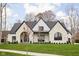 White brick home with black trim, a gabled roof, and a manicured lawn at 10771 Holliday Farms Blvd, Zionsville, IN 46077