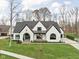 Elegant white brick home with a black roof and landscaped front yard at 10771 Holliday Farms Blvd, Zionsville, IN 46077