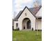 Elegant arched entryway with a black metal door and white brick at 10771 Holliday Farms Blvd, Zionsville, IN 46077