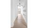 Bright hallway with hardwood floors, built-in shelving, and a view to backyard at 10771 Holliday Farms Blvd, Zionsville, IN 46077