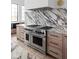 High-end kitchen with marble backsplash, Wolf range, and ample cabinetry at 10771 Holliday Farms Blvd, Zionsville, IN 46077