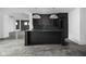 Modern kitchen with dark island and concrete floors at 10771 Holliday Farms Blvd, Zionsville, IN 46077
