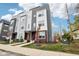 Modern three-story townhome with gray and white siding, red door, and landscaping at 1014 Sterling St, Indianapolis, IN 46201
