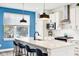 Modern kitchen with white cabinets, blue accent wall, and breakfast bar at 1014 Sterling St, Indianapolis, IN 46201