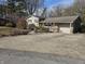 Ranch home with a large concrete driveway and mature trees at 620 Valley Dr, Martinsville, IN 46151