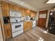Eat-in kitchen with oak cabinets, white appliances, and vinyl flooring at 620 Valley Dr, Martinsville, IN 46151