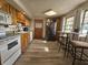 Eat-in kitchen with oak cabinets, white appliances, and vinyl flooring at 620 Valley Dr, Martinsville, IN 46151
