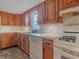 Kitchen boasts wood cabinets, white appliances, and tile flooring at 943 N 12Th St, Elwood, IN 46036