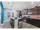 Modern kitchen featuring dark cabinetry, granite island, and a tropical-themed accent wall at 1285 Greenwood Station Blvd, Greenwood, IN 46143