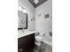 Clean powder room with dark vanity, white toilet, and floral wall decals at 1285 Greenwood Station Blvd, Greenwood, IN 46143