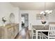 Elegant dining room features a wood table, chandelier, and view into kitchen at 5909 Buttonwood Dr, Noblesville, IN 46062