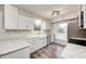 Renovated kitchen boasts white cabinets, marble countertops, and stainless steel appliances at 5909 Buttonwood Dr, Noblesville, IN 46062