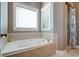 Relaxing bathroom with a large soaking tub and window at 7290 Lockford Walk N, Avon, IN 46123