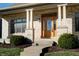 Inviting front entrance with a wood door, brick columns, and landscaping at 7290 Lockford Walk N, Avon, IN 46123