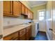 Functional laundry room with washer, dryer, and upper cabinets at 7290 Lockford Walk N, Avon, IN 46123
