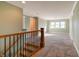 Spacious upper hallway with wood railing and carpeted flooring at 7290 Lockford Walk N, Avon, IN 46123
