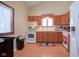 Galley kitchen with wood cabinets and white appliances at 1127 Grant Cir, Cicero, IN 46034