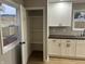 White kitchen cabinets, dark countertop, and pantry at 706 W Franklin St, Thorntown, IN 46071