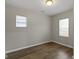 Bright bedroom with two windows, neutral walls, and hardwood floors at 802 N Tuxedo St, Indianapolis, IN 46201