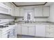 Galley kitchen with white cabinets and modern appliances at 907 S East St, Indianapolis, IN 46225