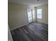 Simple bedroom with gray wood-look flooring and a window with blinds at 8384 Bluestem Ln, Plainfield, IN 46168