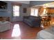 Living room with hardwood floors, gray sofas, and views into kitchen at 3022 N Alaska Rd, Cloverdale, IN 46120