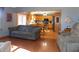 Open living room with hardwood floors, gray sofa, and views of kitchen at 3022 N Alaska Rd, Cloverdale, IN 46120