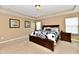 Main bedroom with tray ceiling, dark wood furniture, and window with blinds at 1568 Sussex Dr, Avon, IN 46123