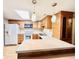 Kitchen with wood cabinets, white appliances, and island at 1632 Wellesley Ct # 6, Indianapolis, IN 46219