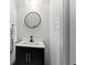 Modern small bathroom with a black vanity and a round mirror at 1542 S Alabama St, Indianapolis, IN 46225