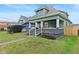 Updated green house with a welcoming front porch and a nicely manicured lawn at 1542 S Alabama St, Indianapolis, IN 46225