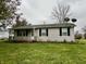 Ranch style home with a covered porch and satellite dish at 3149 E 900 S, Flat Rock, IN 47234
