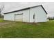 Detached garage with a large overhead door and side entrance at 3149 E 900 S, Flat Rock, IN 47234