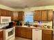 Galley style kitchen with wood cabinets and white appliances at 3149 E 900 S, Flat Rock, IN 47234