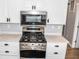 Stainless steel gas range with microwave above, built into white cabinets at 700 S Ohio St, Sheridan, IN 46069