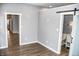 Open concept hallway with gray walls, wood flooring and barn door to bathroom at 700 S Ohio St, Sheridan, IN 46069