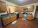 Kitchen with oak cabinets, double sink, and view to living room at 744 Helm Dr, Avon, IN 46123