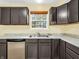 Kitchen with dark cabinets, a double sink, and a window overlooking the backyard at 11411 Shady Hollow Ln, Indianapolis, IN 46229