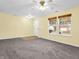 Living room with neutral walls, carpet, and two windows at 11411 Shady Hollow Ln, Indianapolis, IN 46229