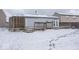 View of backyard deck and surrounding houses in the snow at 2631 Braxton Dr, Indianapolis, IN 46229