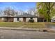 Brick ranch house with a landscaped lawn and attached garage at 3805 Byram Ave, Indianapolis, IN 46208