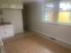 Kitchen boasts white cabinets and tile flooring with a view to the backyard at 3936 Delmont Dr, Indianapolis, IN 46235