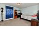 Well-lit bedroom with a double bed, dresser, and window with blue curtains at 7922 S Sherman Dr, Indianapolis, IN 46237
